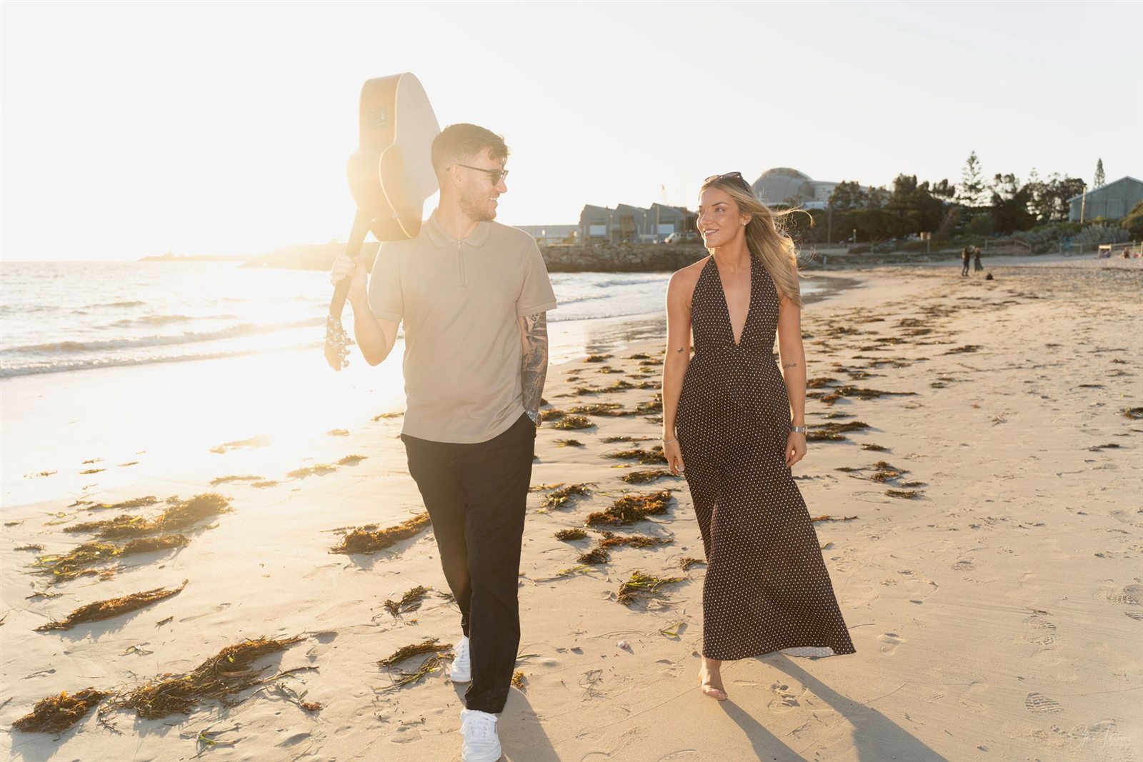 Two On A Visa walking along the beach with an acoustic guitar