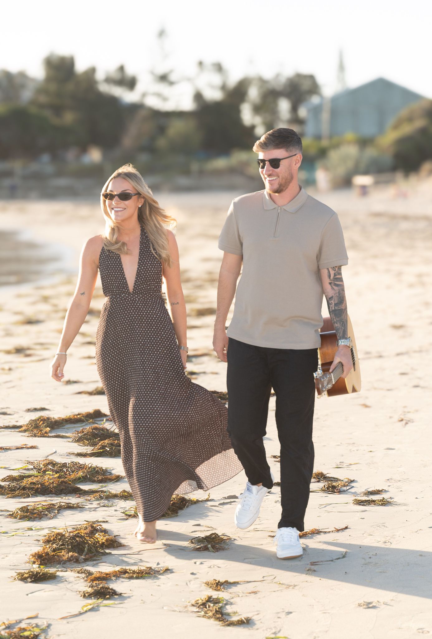 Two On A Visa walking on the beach with a guitar