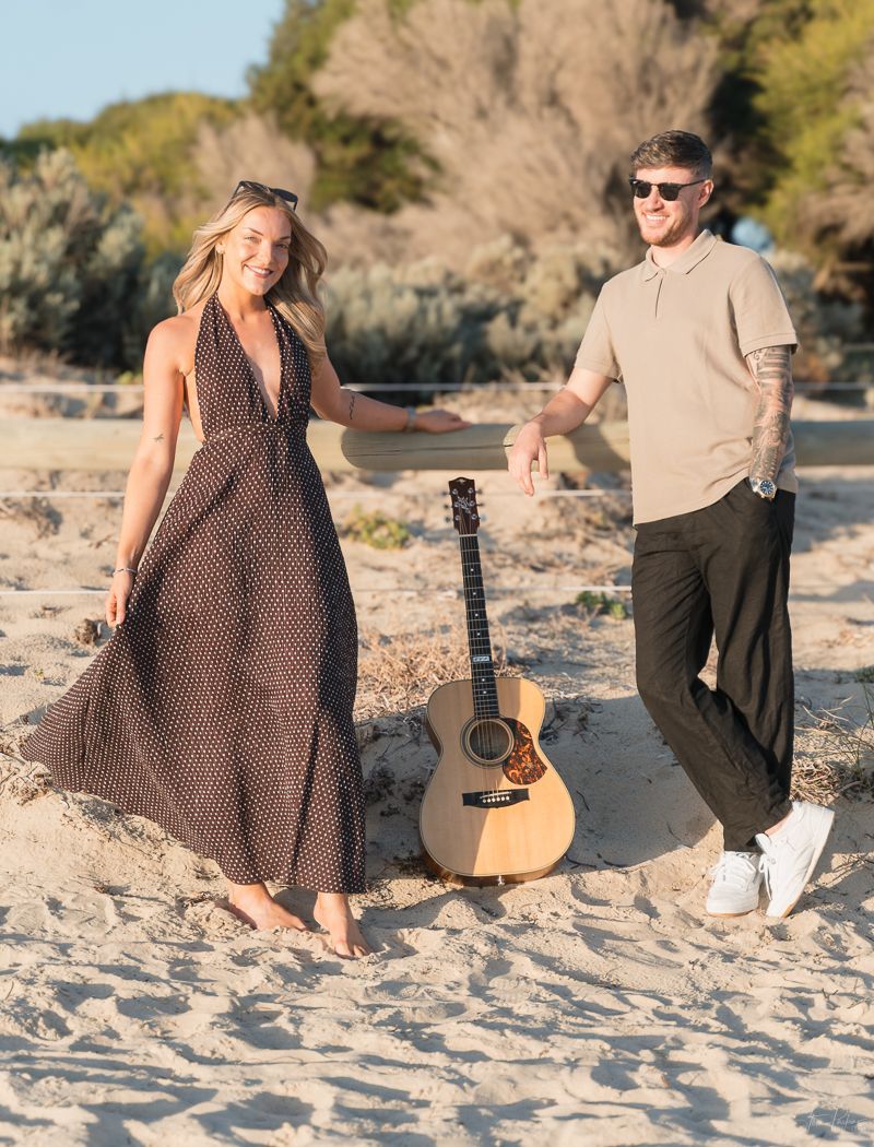 Two On A Visa with an acoustic guitar on the beach